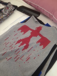 a tee shirt with a red cross on it