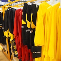 a display of yellow and black t - shirts on a rack