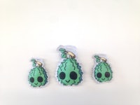 three green bananas on a white surface