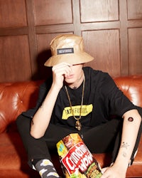a man sitting on a couch with a bucket hat on his head